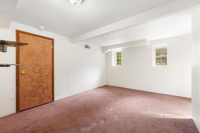 spare room featuring carpet flooring and beam ceiling