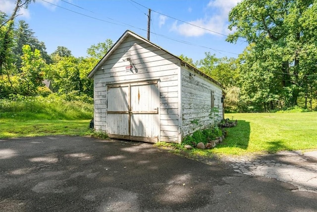 view of outbuilding featuring a yard