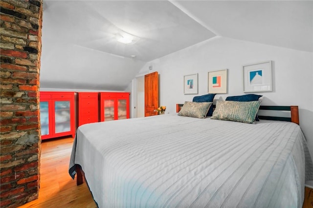 bedroom with hardwood / wood-style flooring and lofted ceiling