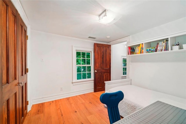 bedroom with a closet and light hardwood / wood-style flooring