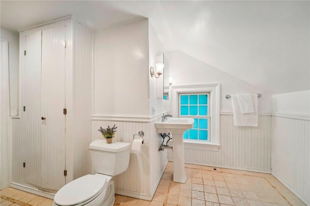 bathroom with lofted ceiling and toilet