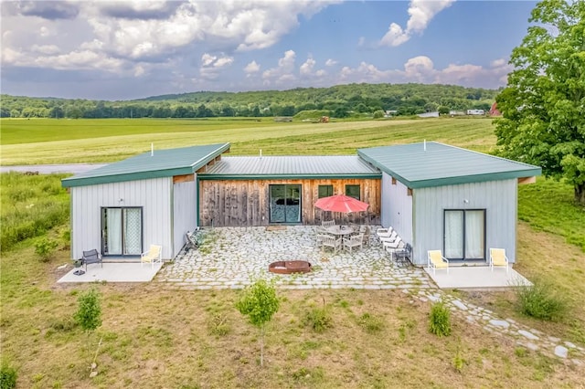 rear view of property with a patio area and a rural view