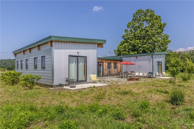 back of property featuring a patio and a lawn