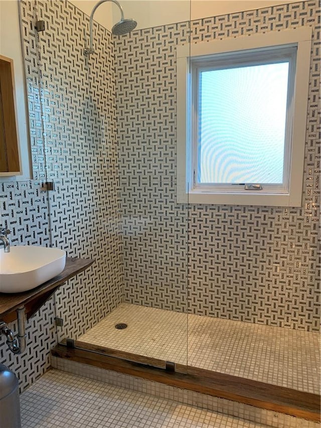 bathroom featuring tile patterned flooring, an enclosed shower, sink, and tile walls