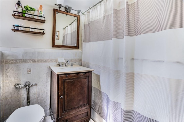 bathroom featuring vanity, curtained shower, toilet, and tile walls