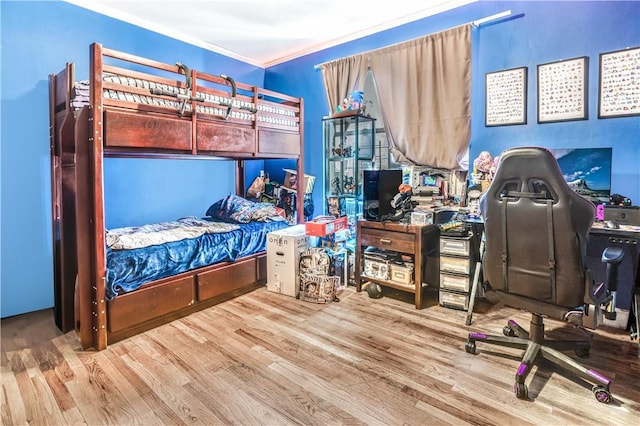 bedroom with hardwood / wood-style floors and ornamental molding