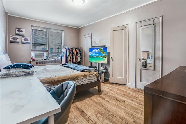 bedroom featuring crown molding and light wood-type flooring