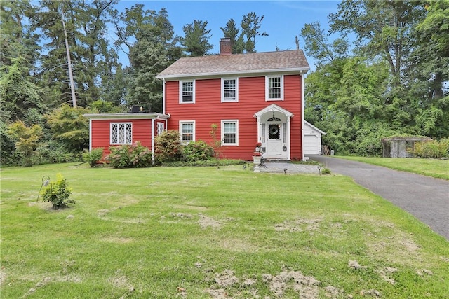 colonial-style house with a garage and a front yard