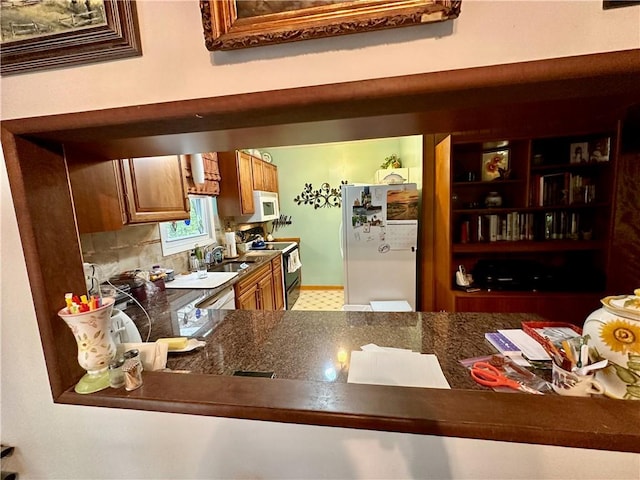 kitchen featuring sink, white appliances, and decorative backsplash