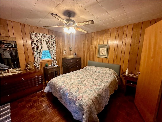 bedroom featuring wooden walls and ceiling fan