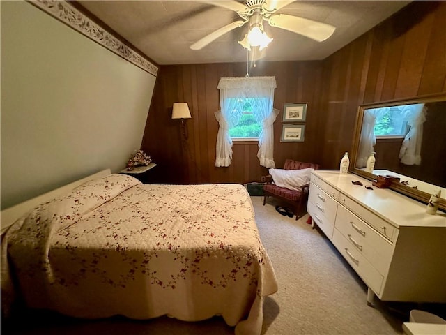 bedroom with carpet, ceiling fan, and wood walls