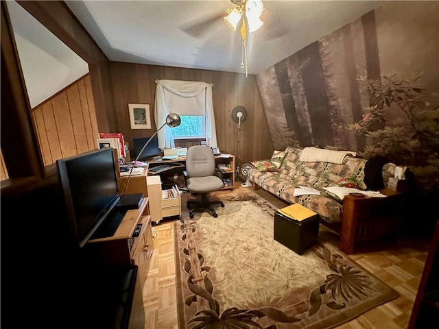 interior space with light parquet floors, ceiling fan, and wooden walls