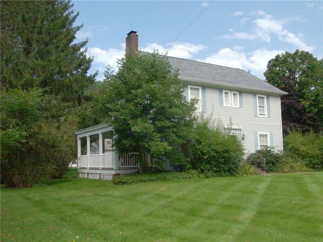 rear view of property with a lawn