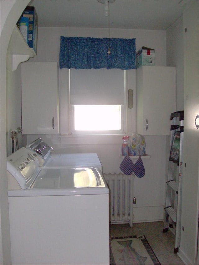 clothes washing area with cabinets, radiator, and washing machine and clothes dryer