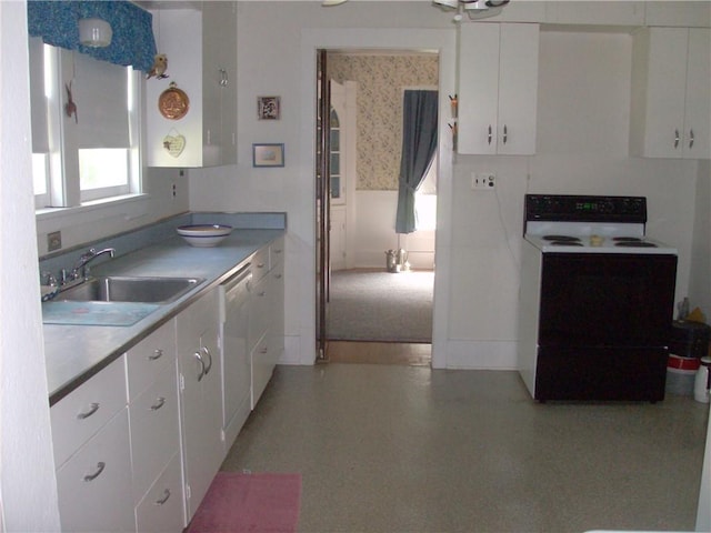 kitchen featuring white range with electric cooktop, white cabinetry, and sink