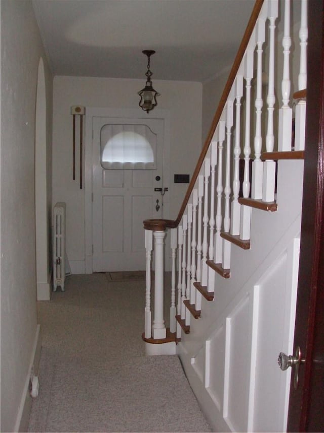 entrance foyer with light carpet and radiator heating unit