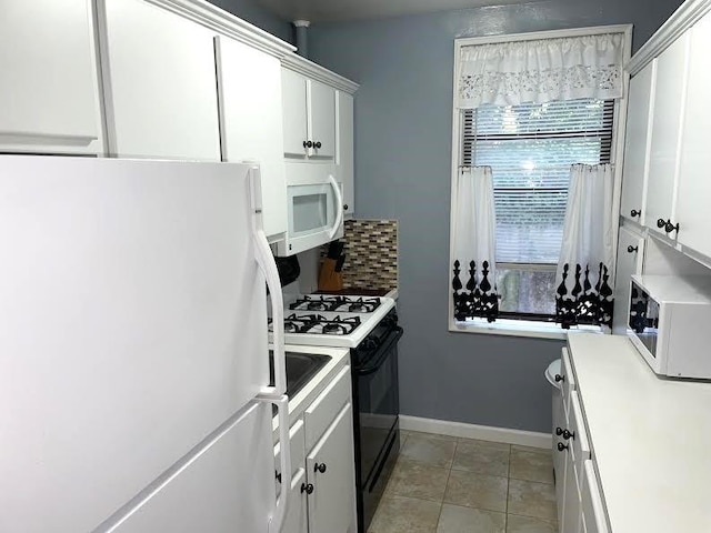 kitchen featuring light tile patterned floors, white appliances, and white cabinetry