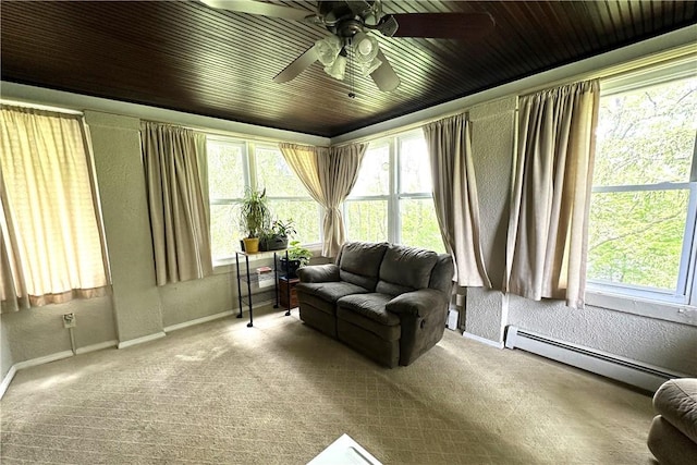 interior space featuring baseboard heating, carpet floors, a wealth of natural light, and ceiling fan