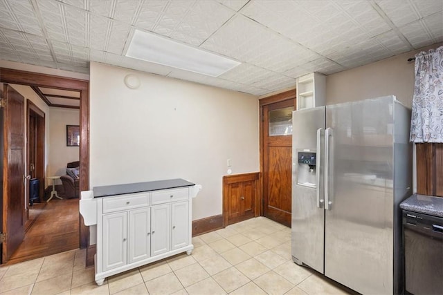 kitchen with white cabinetry, light tile patterned floors, stainless steel refrigerator with ice dispenser, and black dishwasher