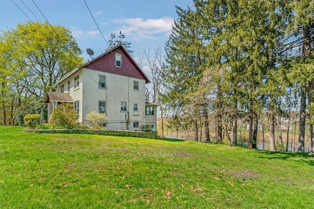 rear view of property featuring a lawn