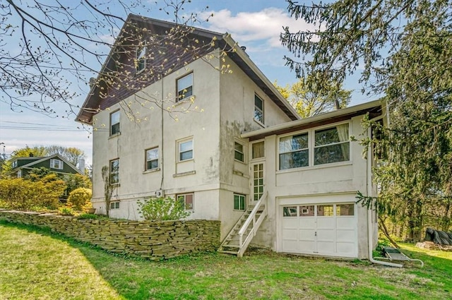 rear view of house with a garage and a yard