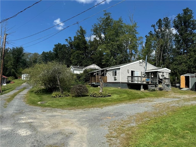 view of home's exterior with a lawn, a storage unit, and a deck