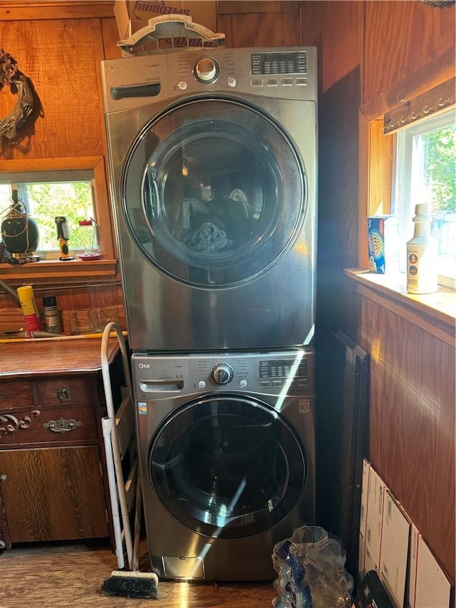 washroom with stacked washer / drying machine, a wealth of natural light, and light hardwood / wood-style flooring