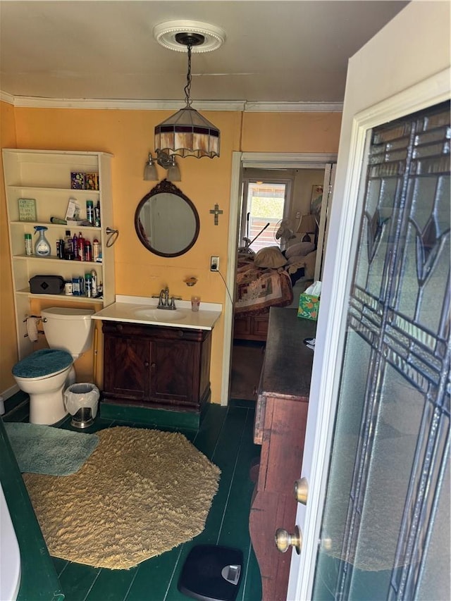 bathroom with tile patterned flooring, vanity, ornamental molding, and toilet