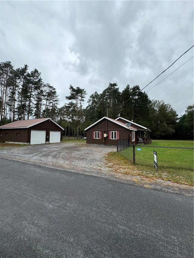 view of front of home with a garage, an outbuilding, and a front lawn