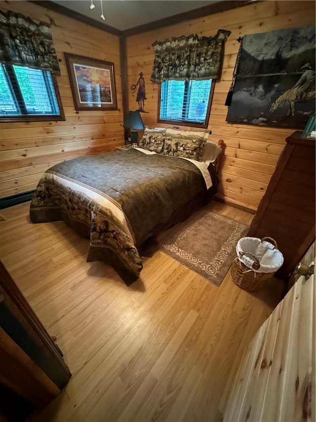 bedroom with wooden walls and wood-type flooring