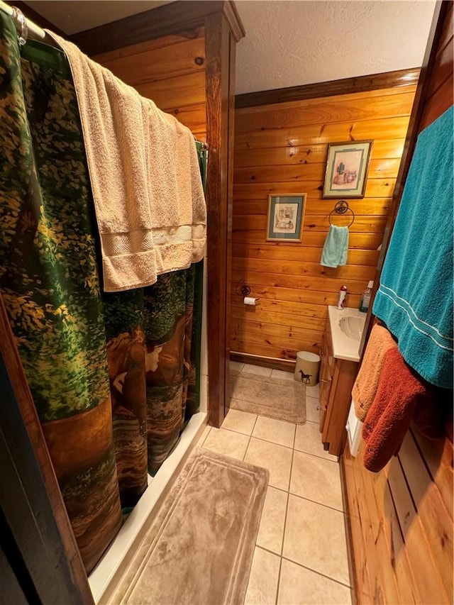 bathroom featuring vanity, tile patterned floors, and wooden walls