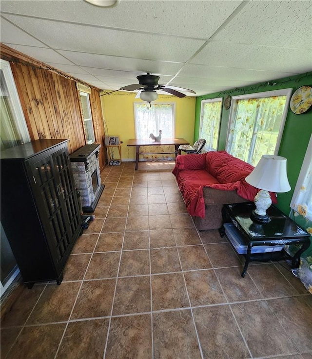 tiled living room featuring a paneled ceiling and ceiling fan