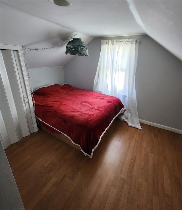 bedroom with wood-type flooring and lofted ceiling