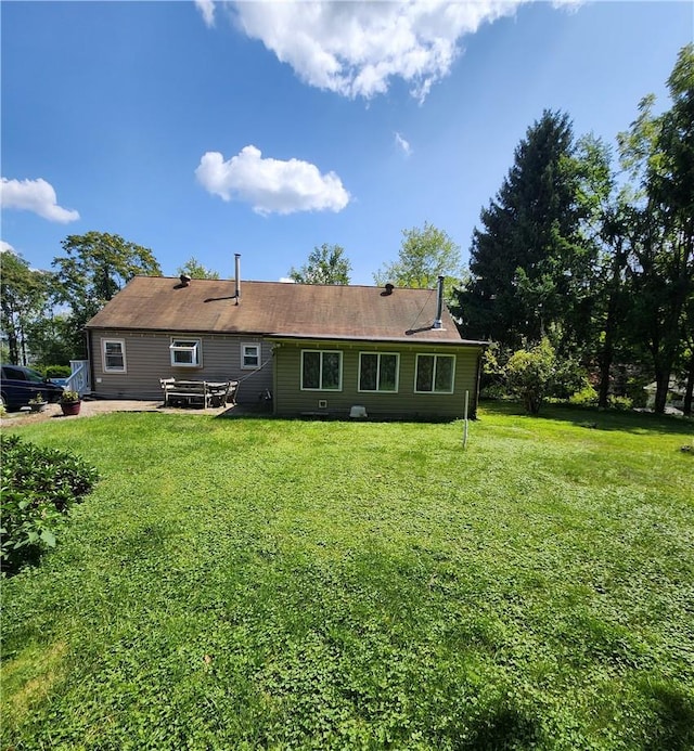 rear view of property featuring a yard and a patio