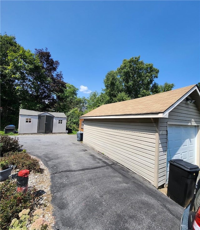 view of side of property featuring a storage unit and a garage