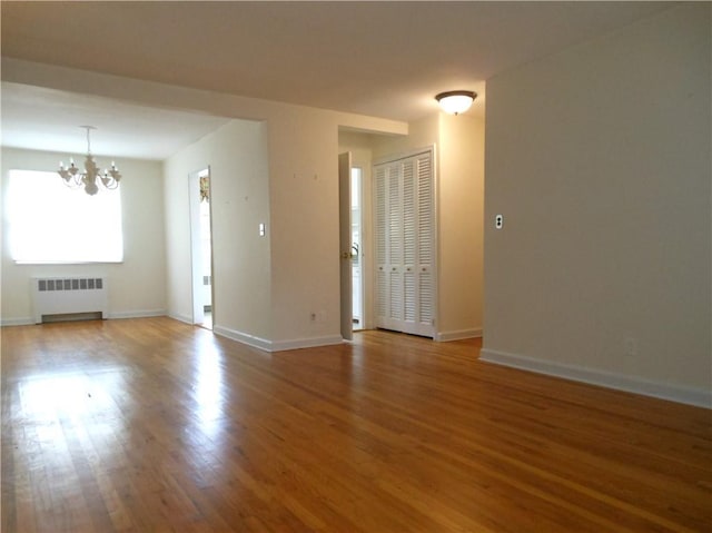 861 Palisade Ave Unit 2D, Yonkers, NY 10703 - spare room featuring radiator heating unit, a chandelier, wood finished floors, and baseboards