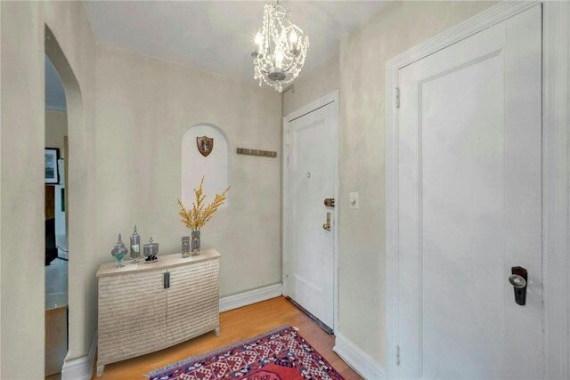 280 Bronxville Rd Unit 9B, Bronxville, NY 10708 - entryway with arched walkways, light wood-style floors, and a chandelier