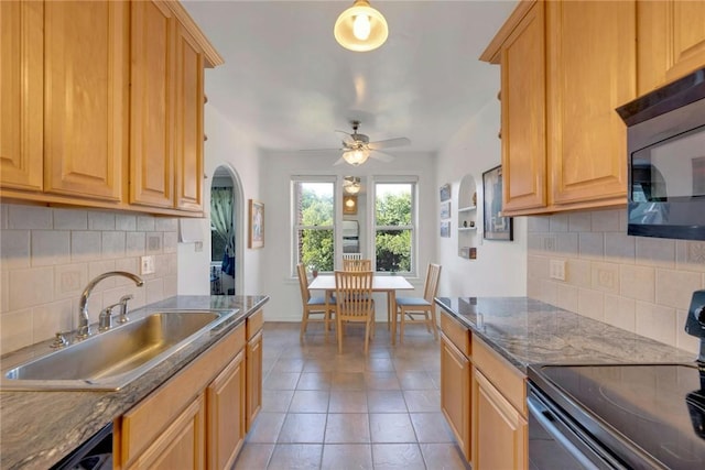 kitchen with ceiling fan, sink, tasteful backsplash, dark stone counters, and black appliances