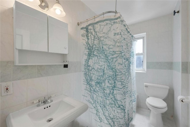 bathroom with a shower with curtain, toilet, sink, and tile walls