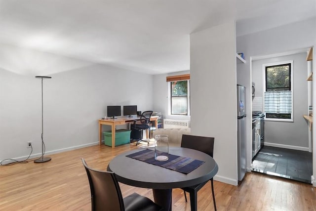 dining room featuring radiator heating unit and light wood-type flooring