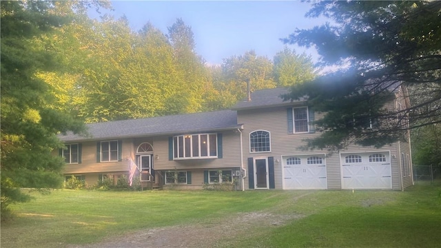 split foyer home featuring a garage and a front yard