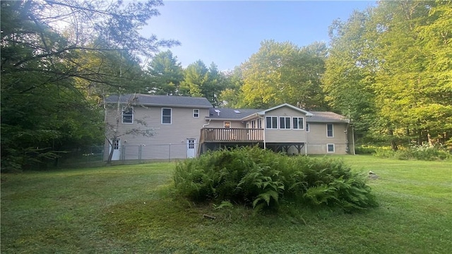 rear view of house featuring a deck and a lawn