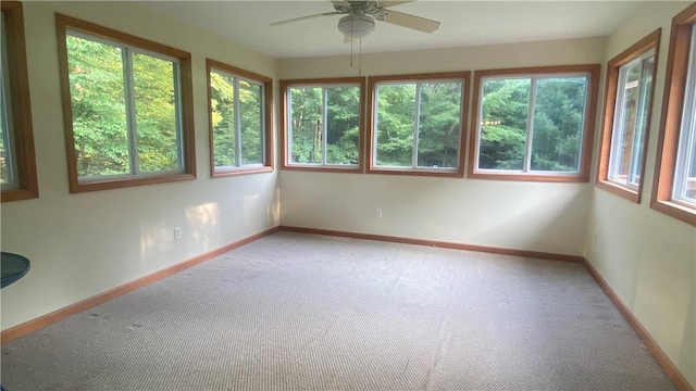 unfurnished sunroom featuring ceiling fan