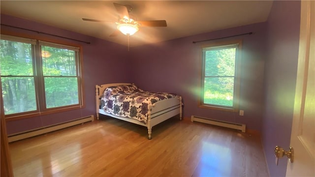 bedroom featuring ceiling fan, a baseboard radiator, and wood-type flooring