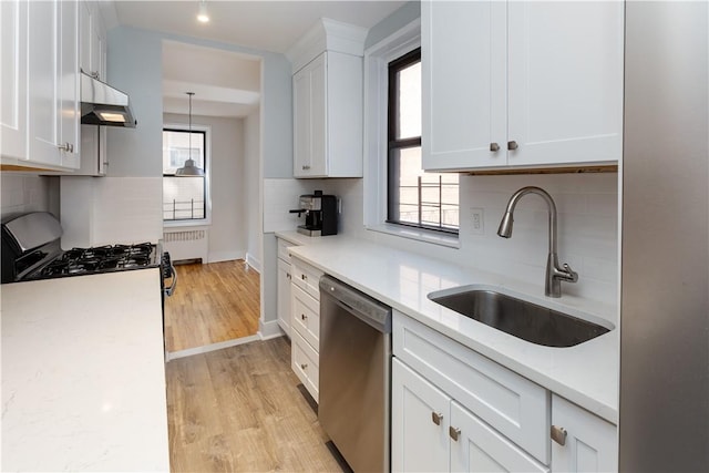 kitchen featuring dishwasher, a healthy amount of sunlight, decorative backsplash, and sink