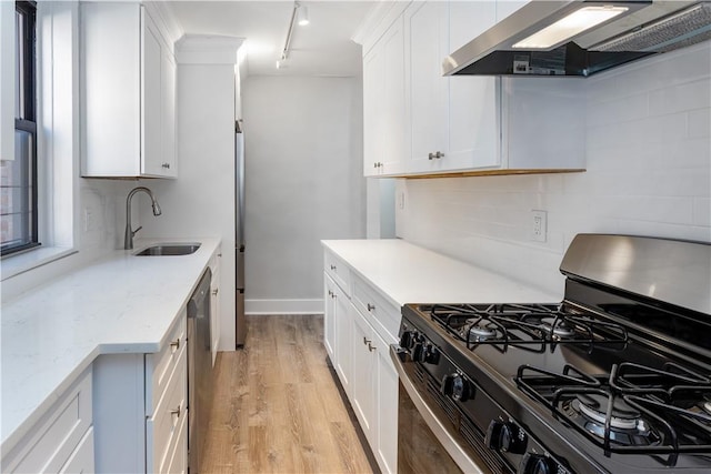 kitchen with ventilation hood, white cabinets, black gas stove, sink, and light hardwood / wood-style floors