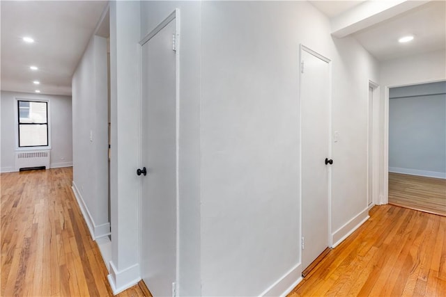 hallway featuring radiator and light hardwood / wood-style floors