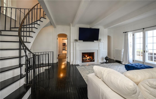 living room with beam ceiling, radiator heating unit, wood-type flooring, and french doors