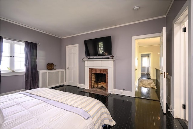 bedroom featuring a fireplace, crown molding, and dark wood-type flooring