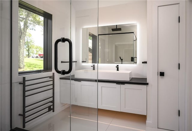 bathroom featuring tile patterned flooring, a shower, and vanity